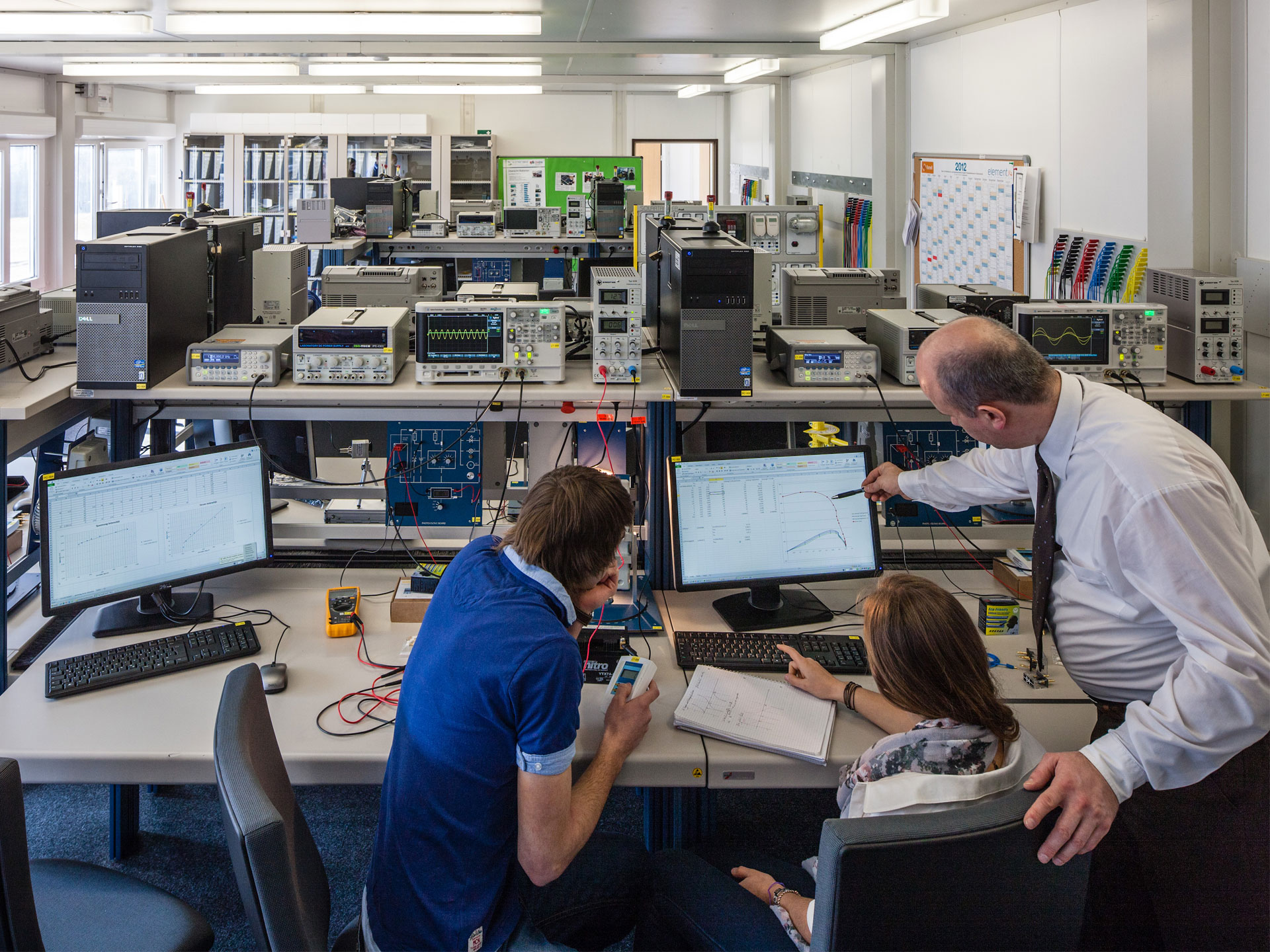 Professer erklärt Studierenden Elektrotechnik - Nachrichten- und Kommunikationstechnik
