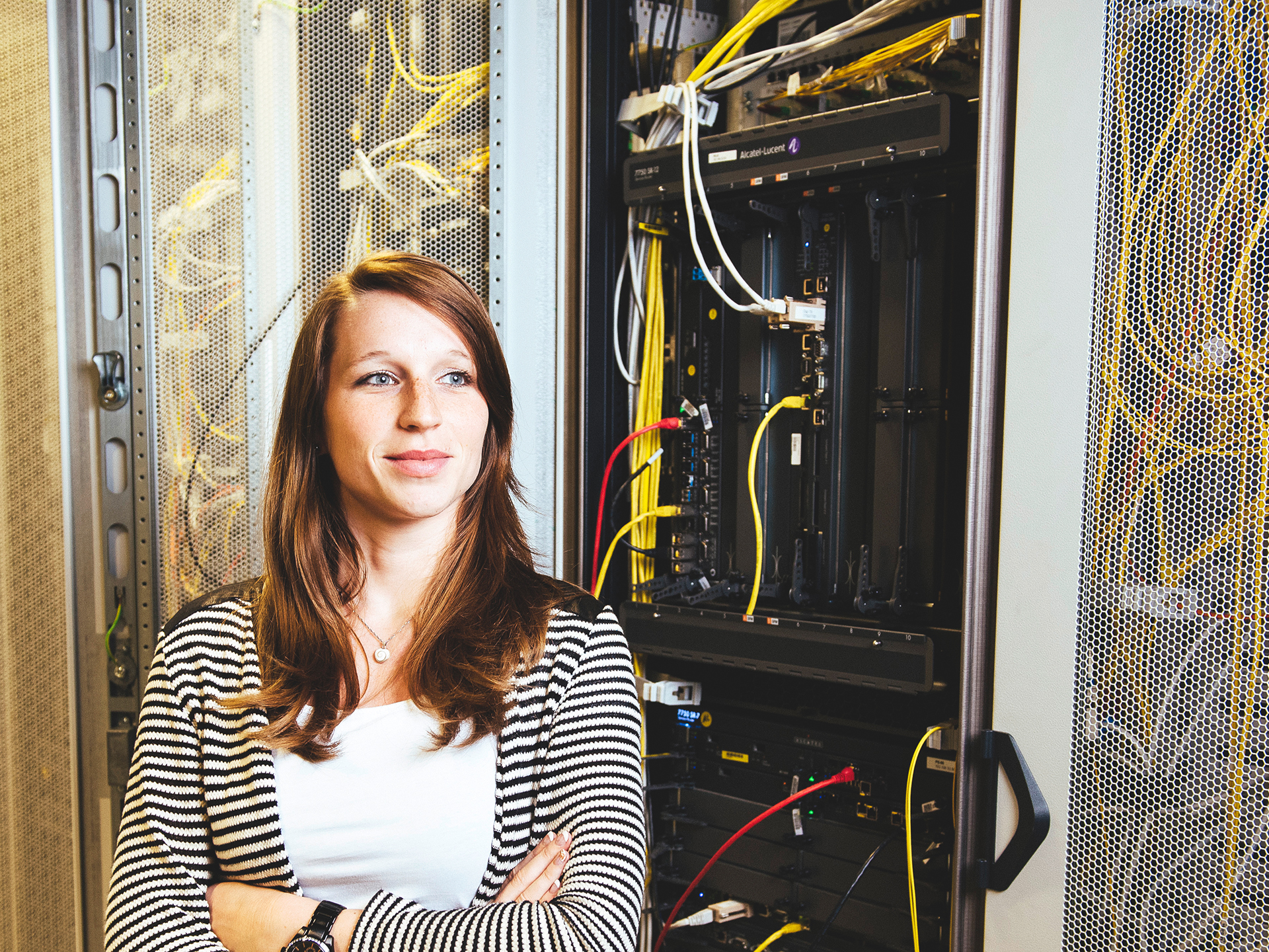 Eine Frau steht selbstbewusst vor einer technischen Anlage