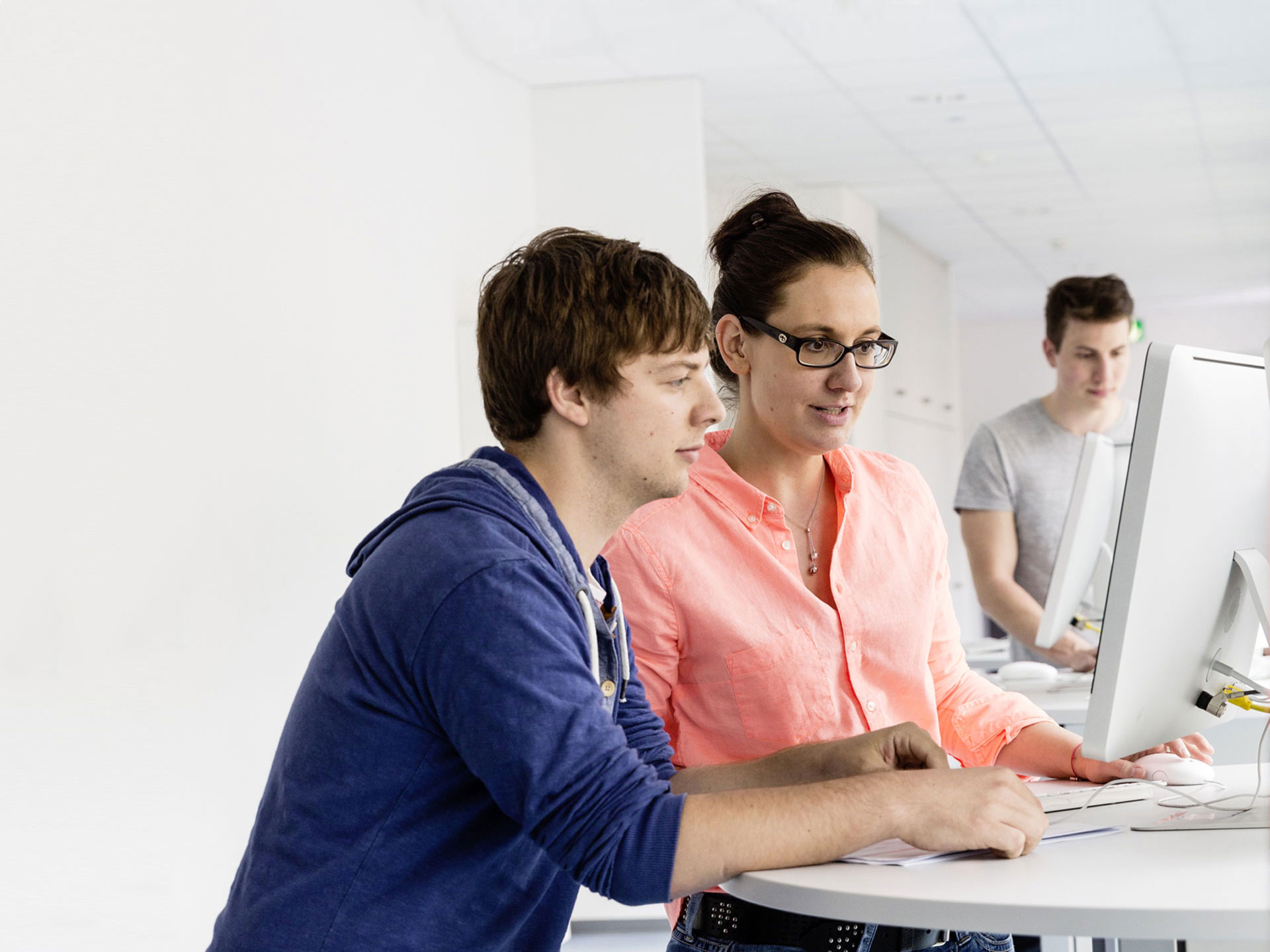 Studierende arbeiten gemeinsam am PC