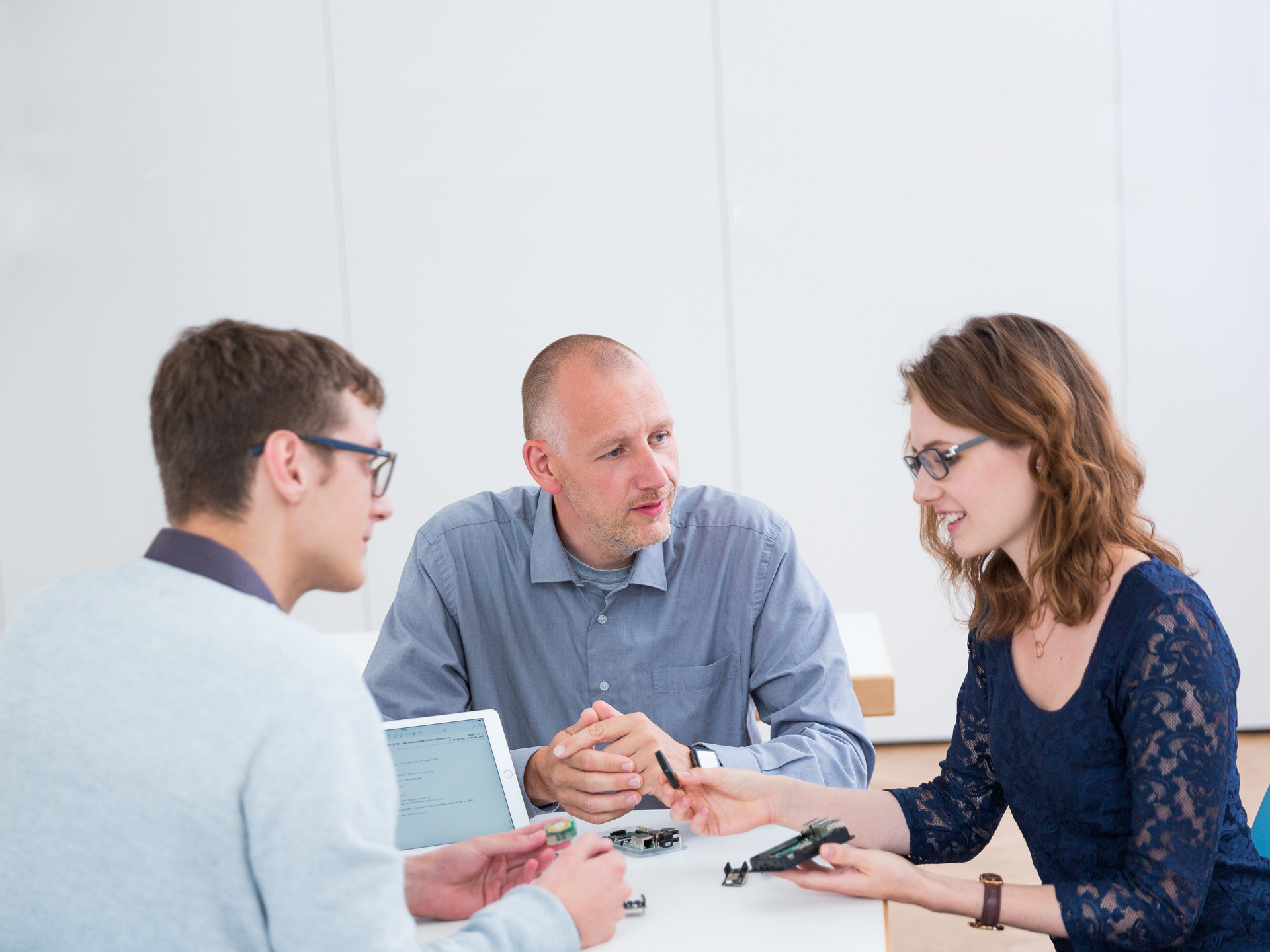 Studierende zeigen ihrem Professor ihr Projekt im Studiengang Informatik