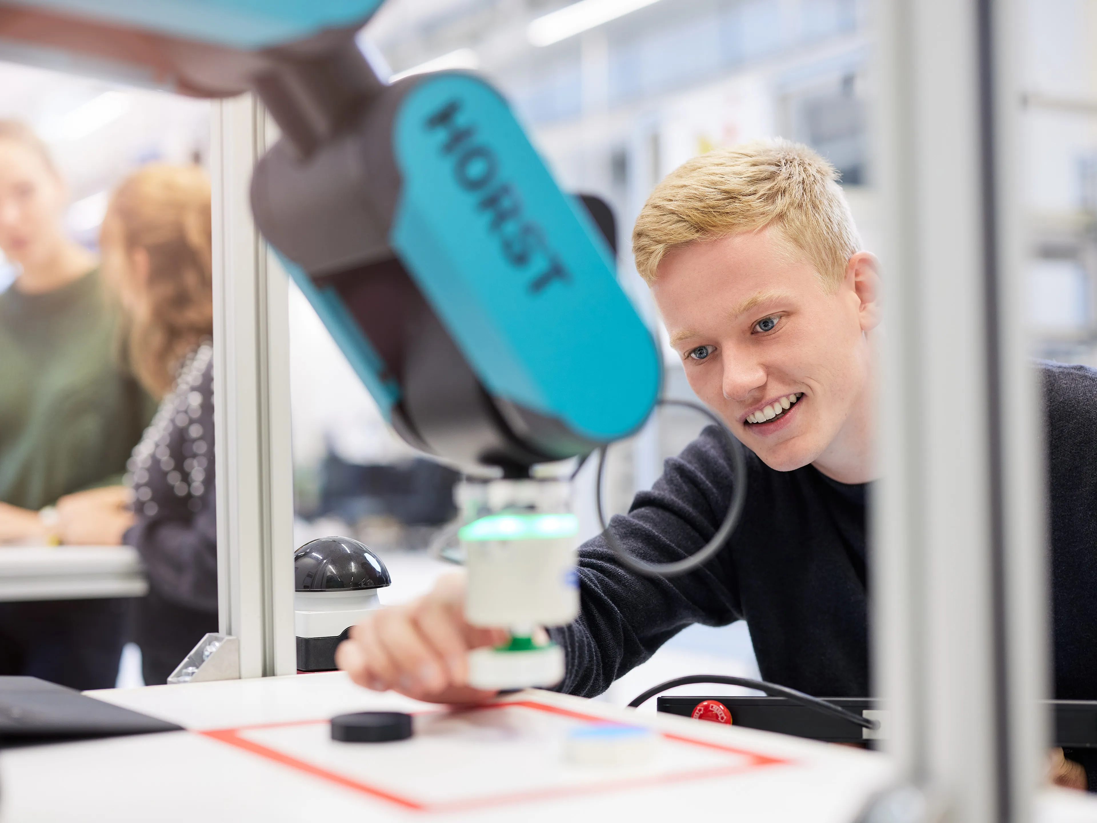 Studierender im Mechatronik-Studium arbeitet mit Roboter