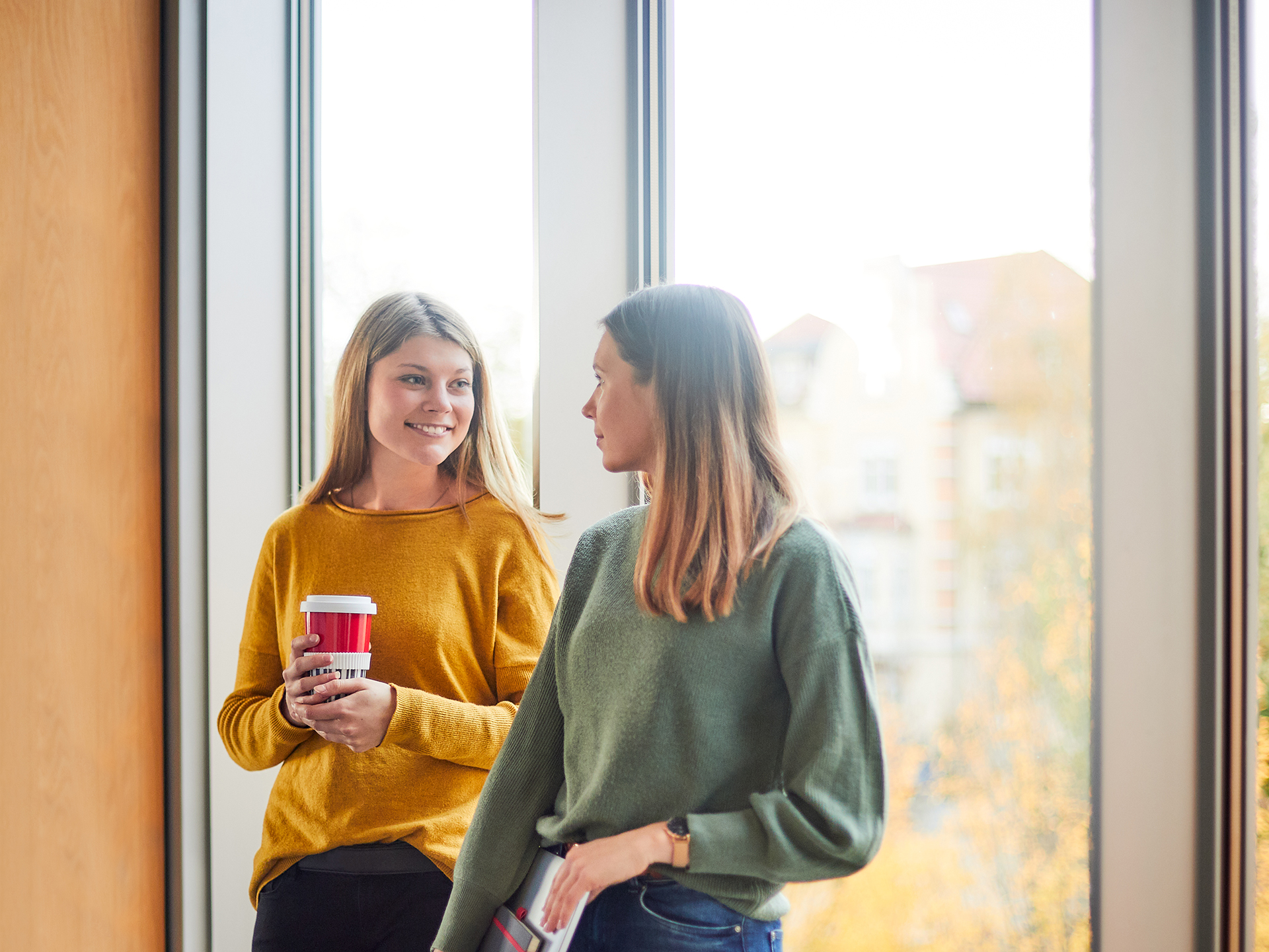 Zwei Studentinnen vor einem Fenster