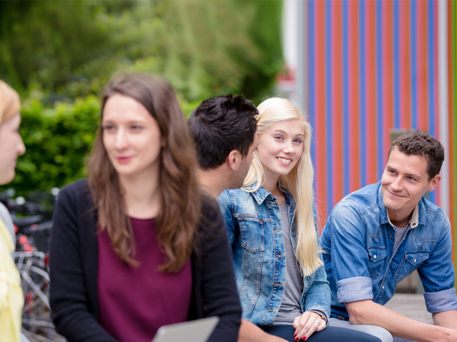 Gruppe von Studierenden beraten sich vor der Hochschule