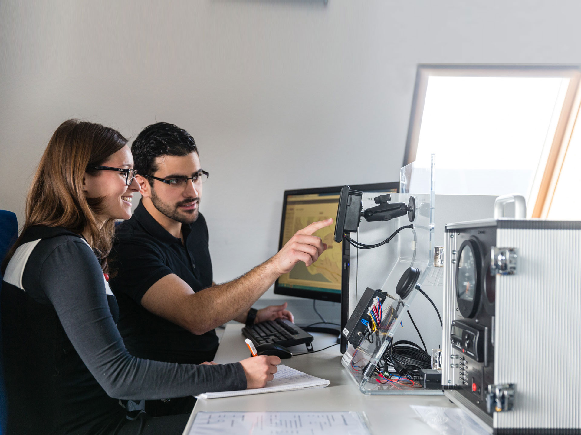 Student zeigt Studentin Funktionsweise einer Software im Wirtschaftsingenieurwesen