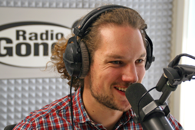 Simon Steffan mit Kopfhörern vor einem Radio-Mikro