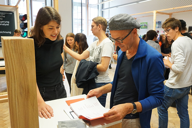 Studentin stellt Besucher ihre Bachelorarbeit vor