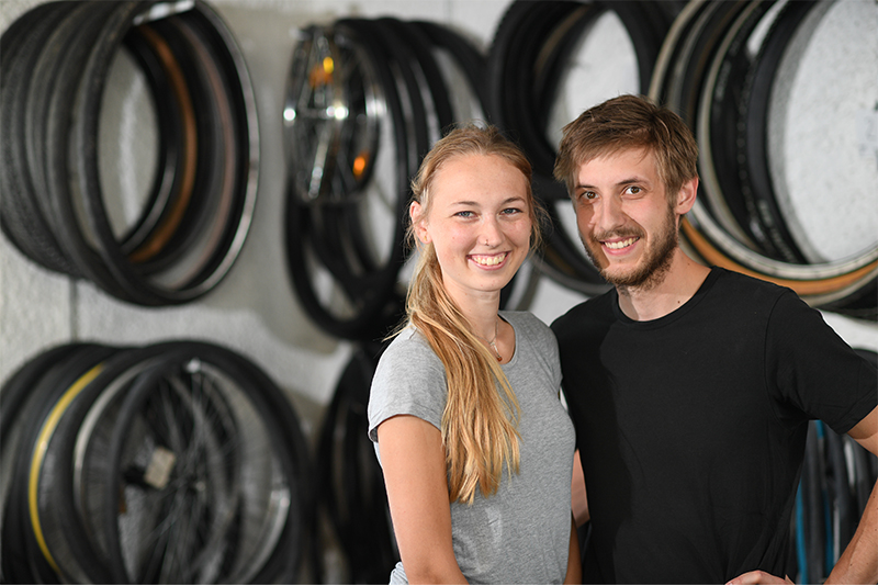 Lara Kroesen und Wolf-Michael Dieter vor aufgehängten Fahrradreifen