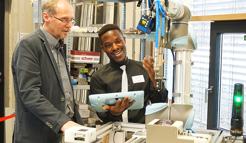 Professor und Student an einem Roboter