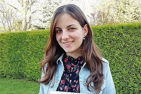 Porträt Corinna Häringer vor einer grünen Hecke