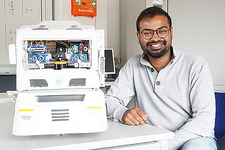 Doktorand Chaitanya Grandhi neben einem Roboter der ZF