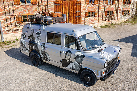 Erzählbus auf Schotterparkplatz