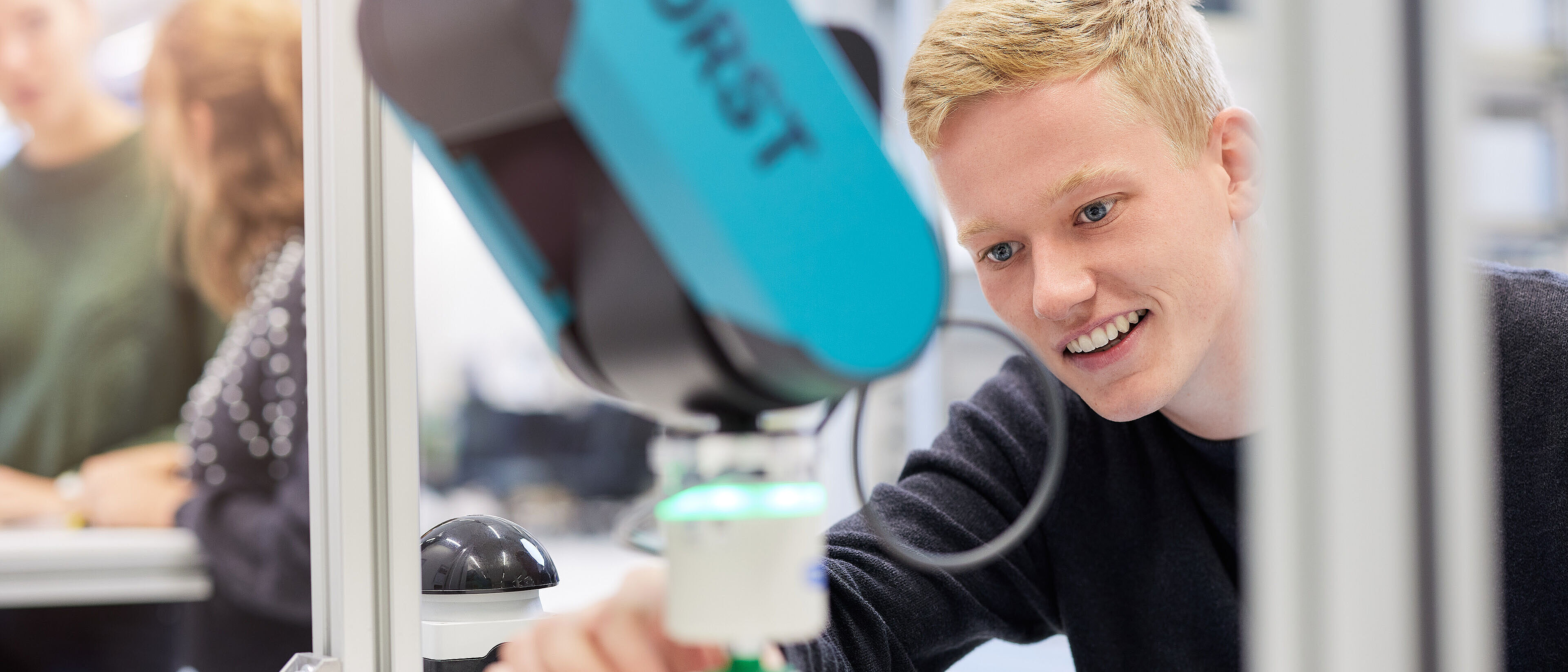 Studierender im Mechatronik Studium arbeitet mit einem Roboter