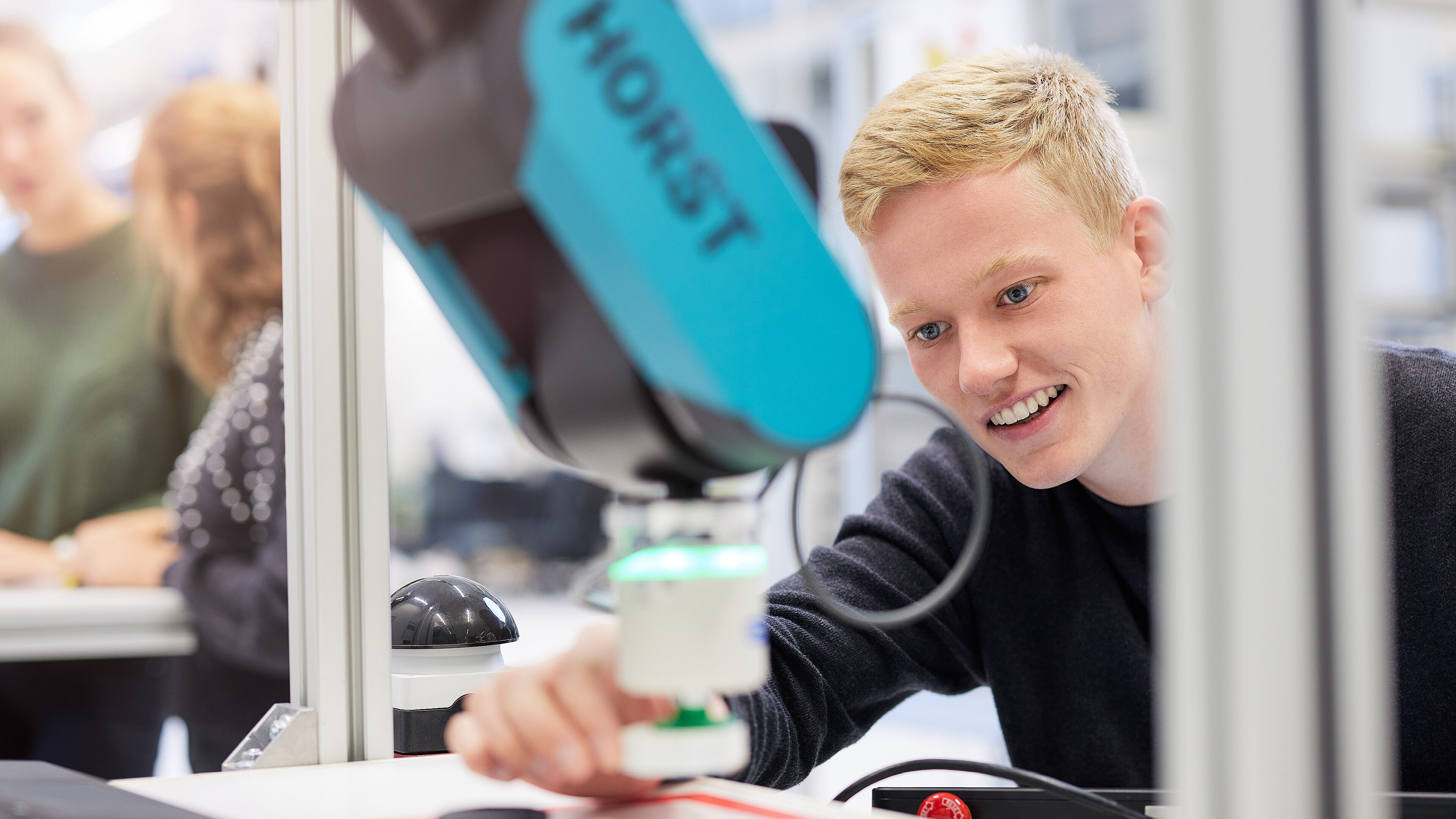 Studierender im Mechatronik Studium arbeitet mit einem Roboter