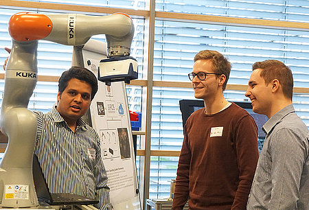 Drei Studenten am Roboter